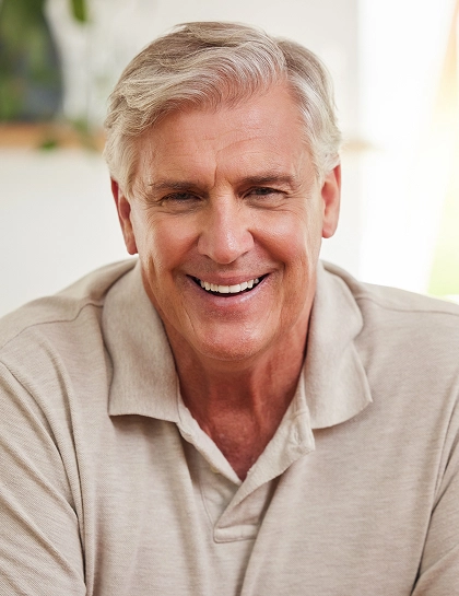 a older man smiling after attached dental implants in Culver City