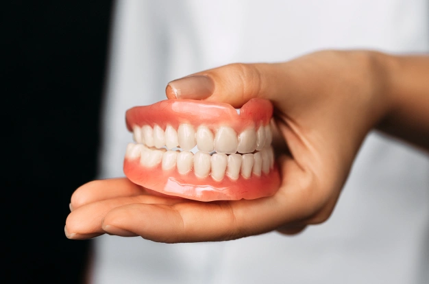 a dentist holding a dental denture module