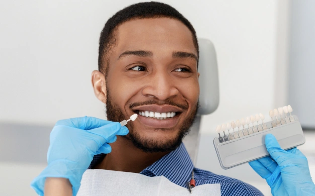 a black man seating dentist chair and ready to attaching dental veneers in Culver City